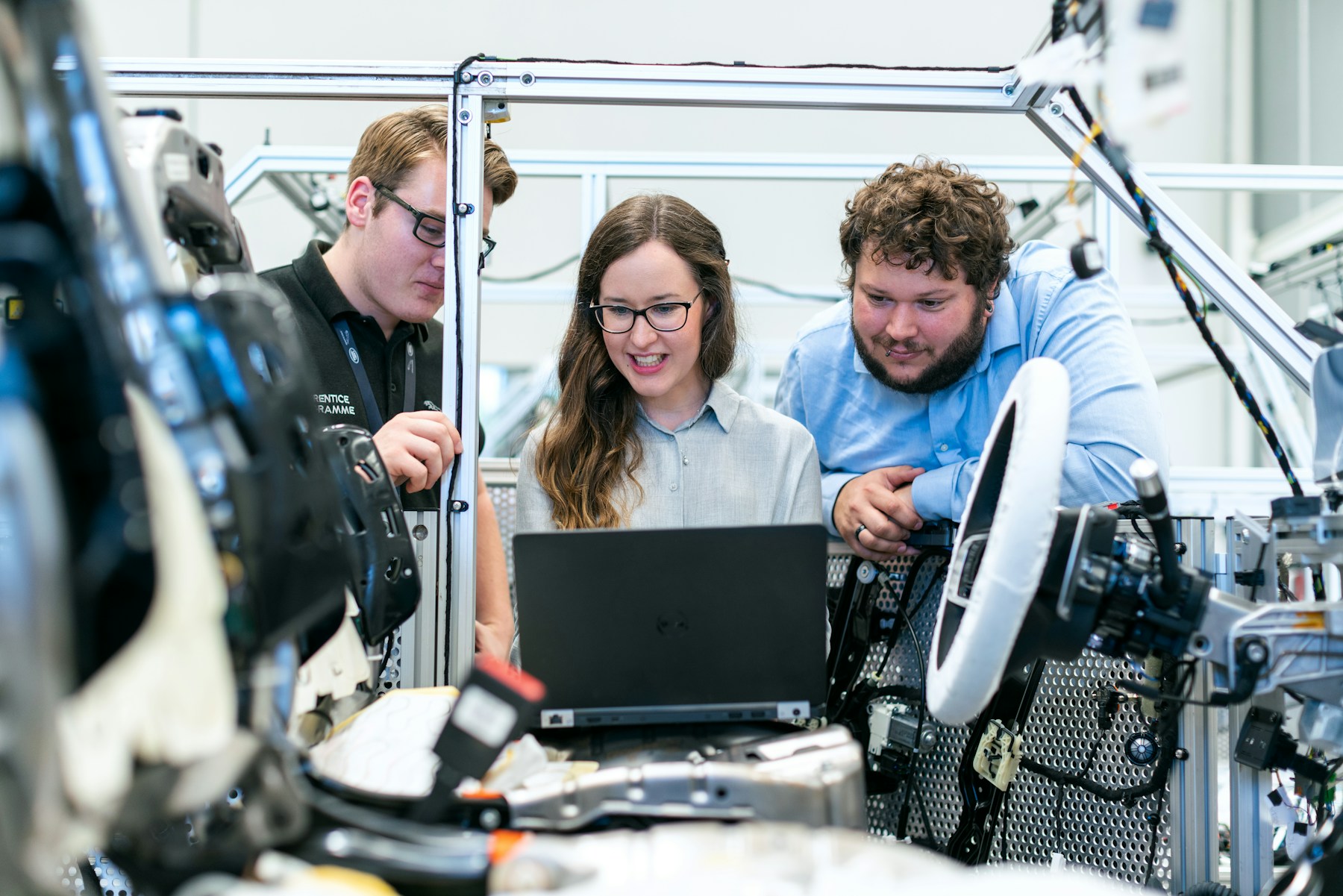 Engineering team reviewing a laptop alongside technical test equipment