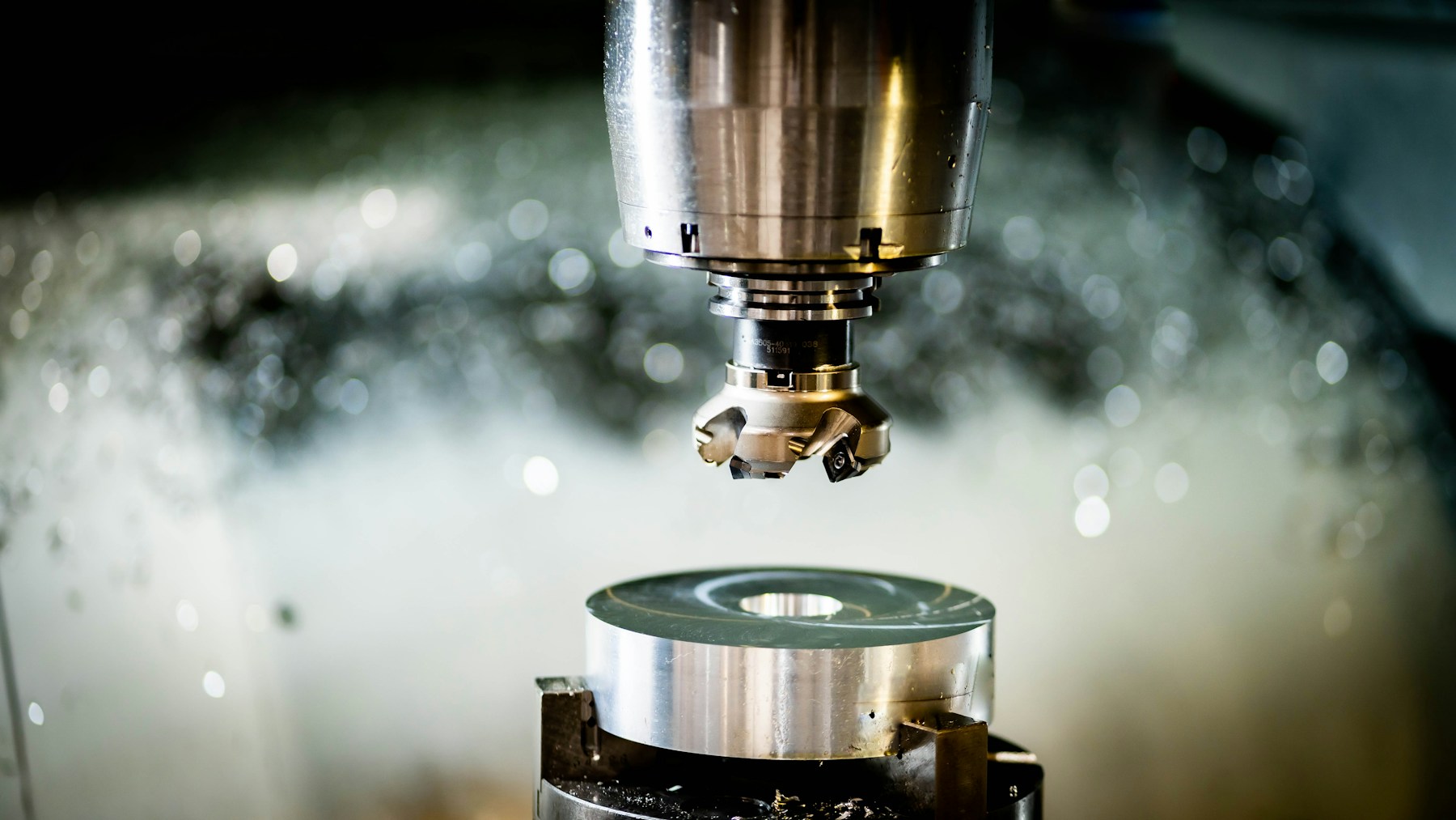 Indexable face milling cutter with visible cutting inserts above a machined component
